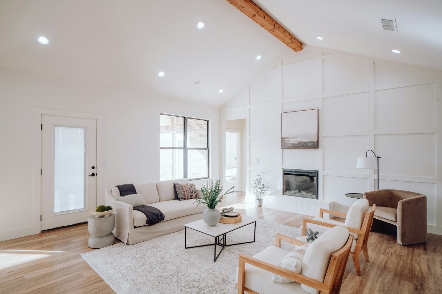 Modern living room with cream sofa and wood accent chairs.